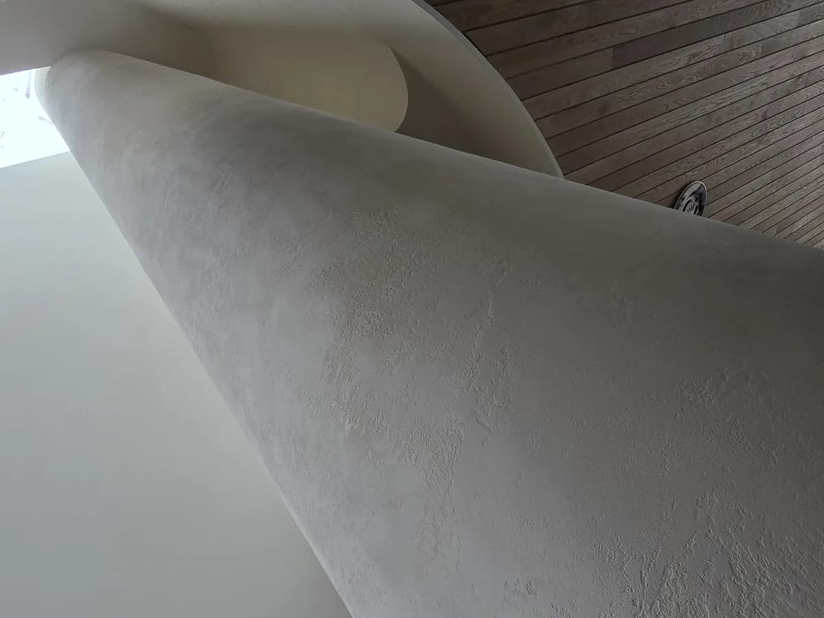 Microcement being applied by hand to a curved surface